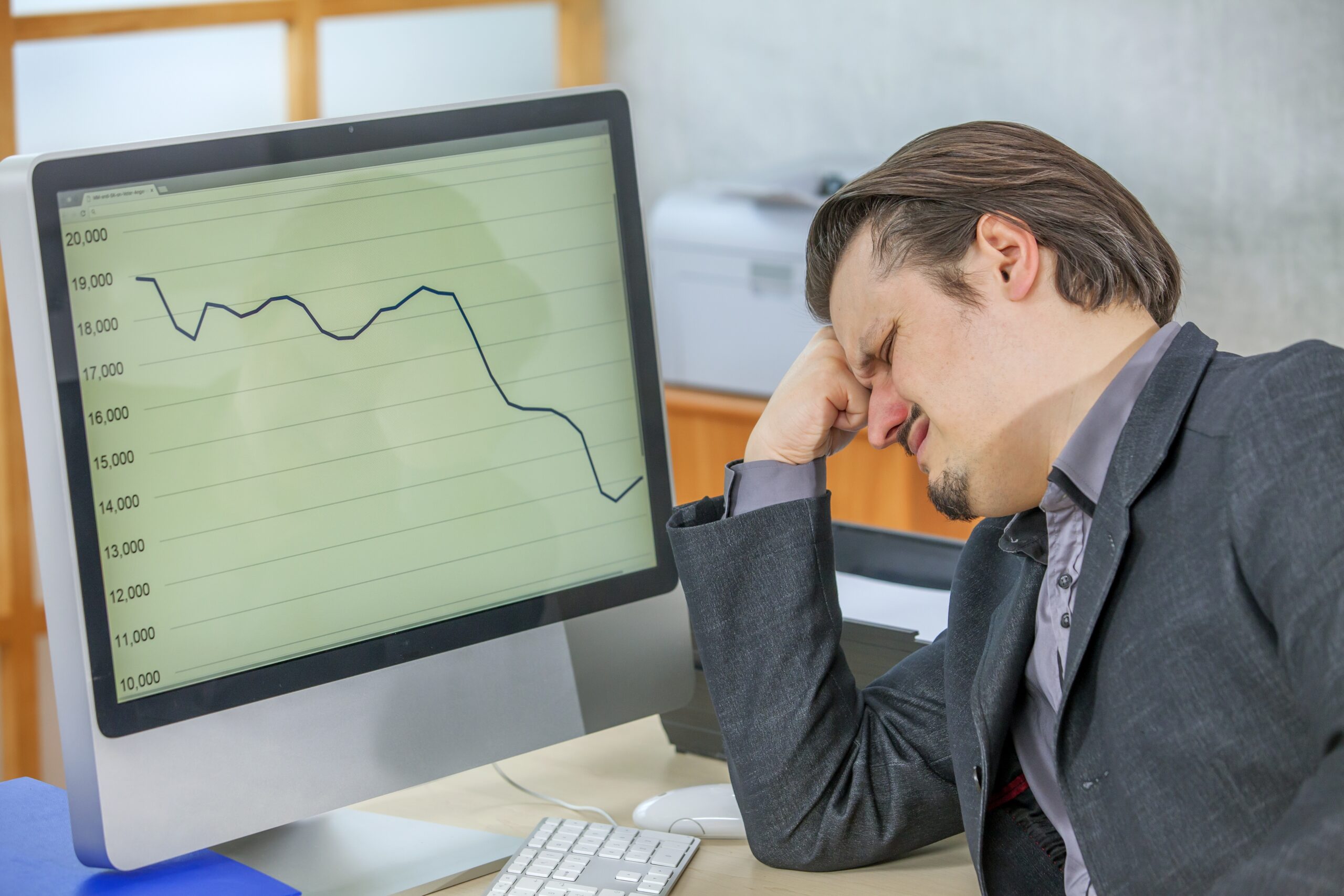 A businessman is not satisfied with this months' business results and looks worried.