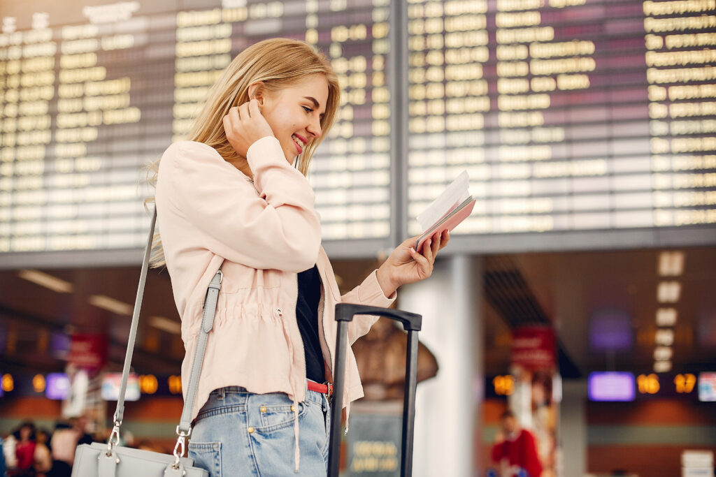 Girl in a airport. Blonde with a documents. Lady in a black t-shirt