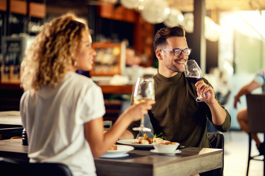 Happy couple drinking wine while eating lunch in a restaurant.